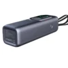 Mørk grå Reisegrossisten RG1 powerbank liggende med skjerm, klokkelader og samlede USB-C-kabler